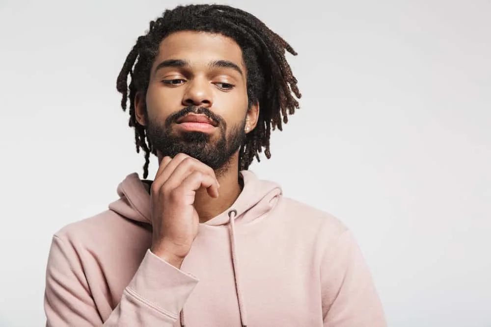 How Much Do Starter Locs Cost? Should You DIY Starter Locs? 7 A black male with thick hair is thinking about setting up a starter loc appointment to restart his loc journey.