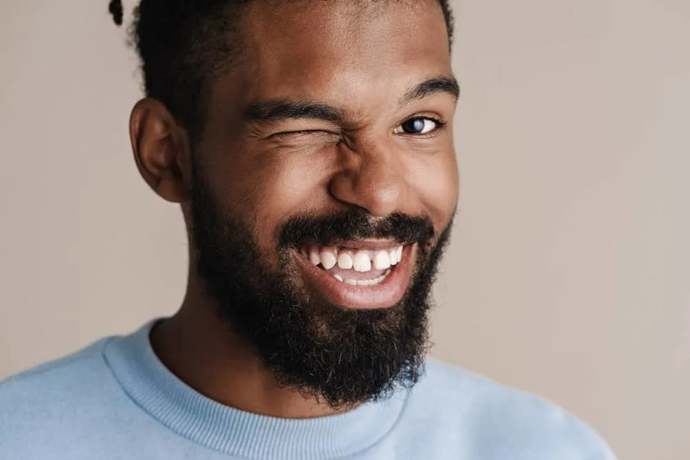 How Often Should You Oil Your Locs? Should You Oil Them Daily? 3 A joyful black man with medium hair shaft thickness has been moisturizing locs with a bi-weekly hot oil treatment.