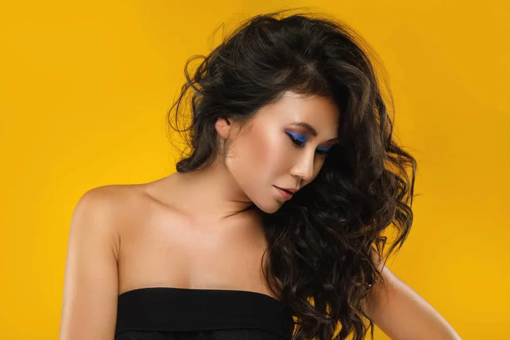 23 Best Hairstyles for Asian Women With Short, Medium & Long Hair 10 Lady with a dark skin tone wearing her thick hair in wispy layers similar to many popular Asian girls with short hair.