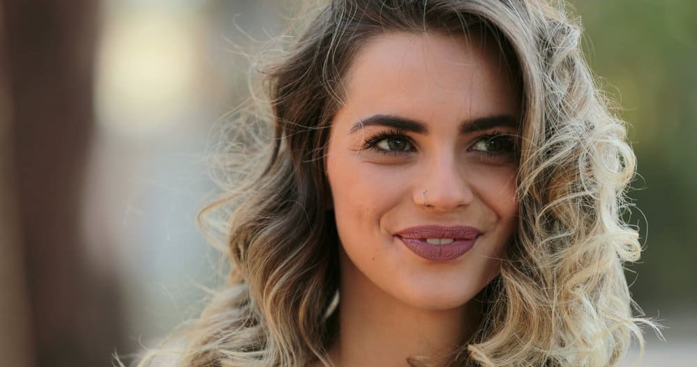 A lady covering gray hair by "gray blending" her dark brown natural shade with silver hair lowlights.