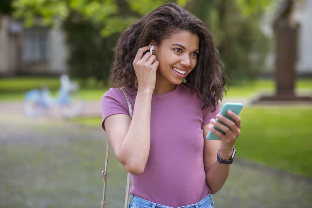 A light-skinned girl in a great mood researching what makes her hair stiff and trying to understand the hair's surface.