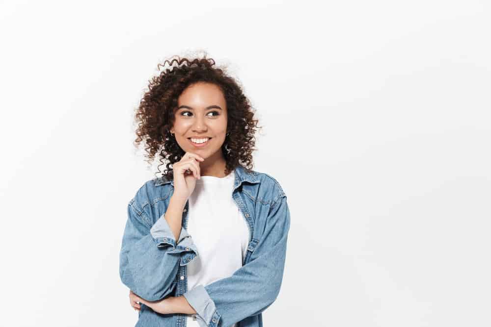 A cute African American female that's growing out layers after having longer layers and bangs on her natural curls.