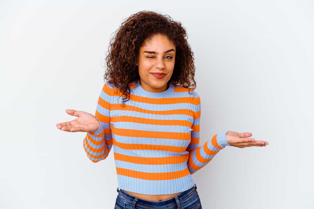 A black girl with damaged hair after using an over-the-counter boxed hair dye to create a mixed black and brown color.