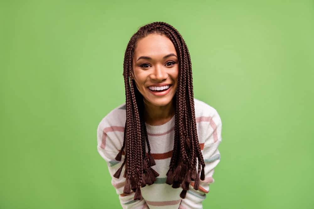 A happy American female wearing softened, dry synthetic hair braids loosened with a hot air brush and conditioner.