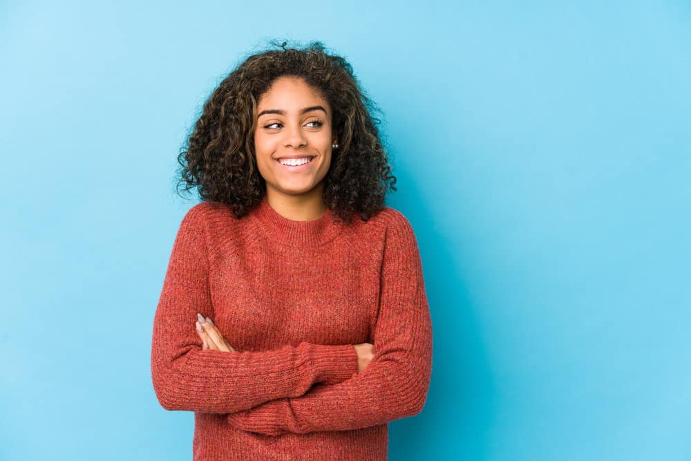 A confident African American female with healthy hair follicles styled with essential oils and leave-in conditioners.