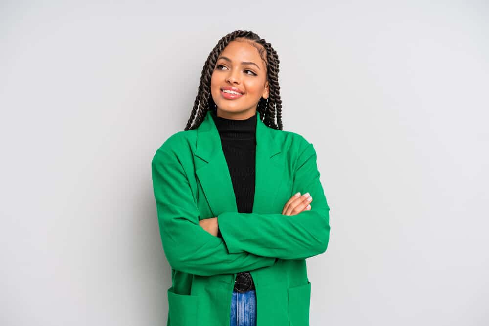 A black female wearing loose twists has edges styled with natural oils and alcohol-free moisturizing techniques.