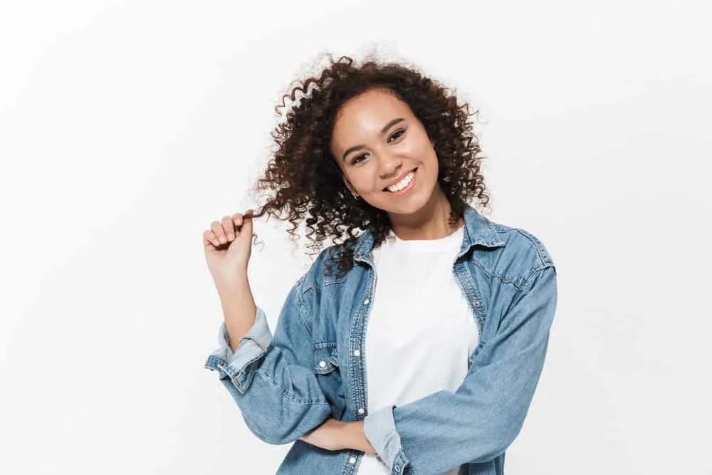 How to Get Rid of Layers in Hair: DIY Step-by-Step Guide 3 A young African female with a 3B hair type wearing a style created with a curling iron without any hair accessories.