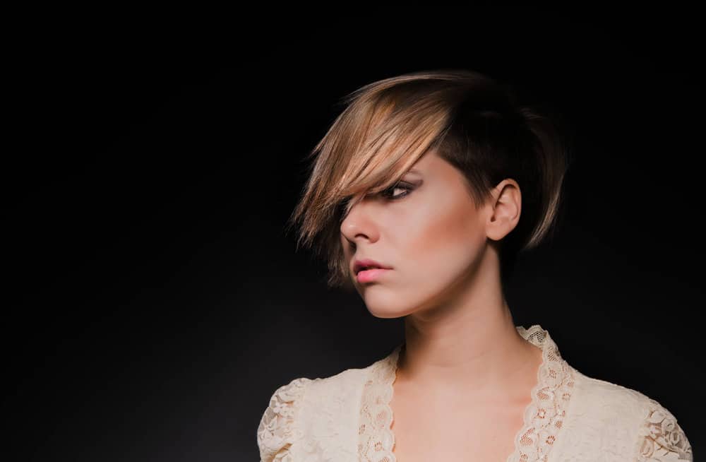 A cute young white lady with short hair that's growing out a pixie haircut that was cut into several different lengths.