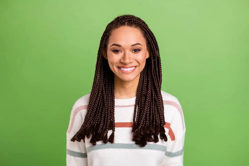 How To Soften Synthetic Braids: Step-by-Step for Beginners 2 Black female with fresh braids after making her synthetic hair soft using a wide-tooth comb and lukewarm water.