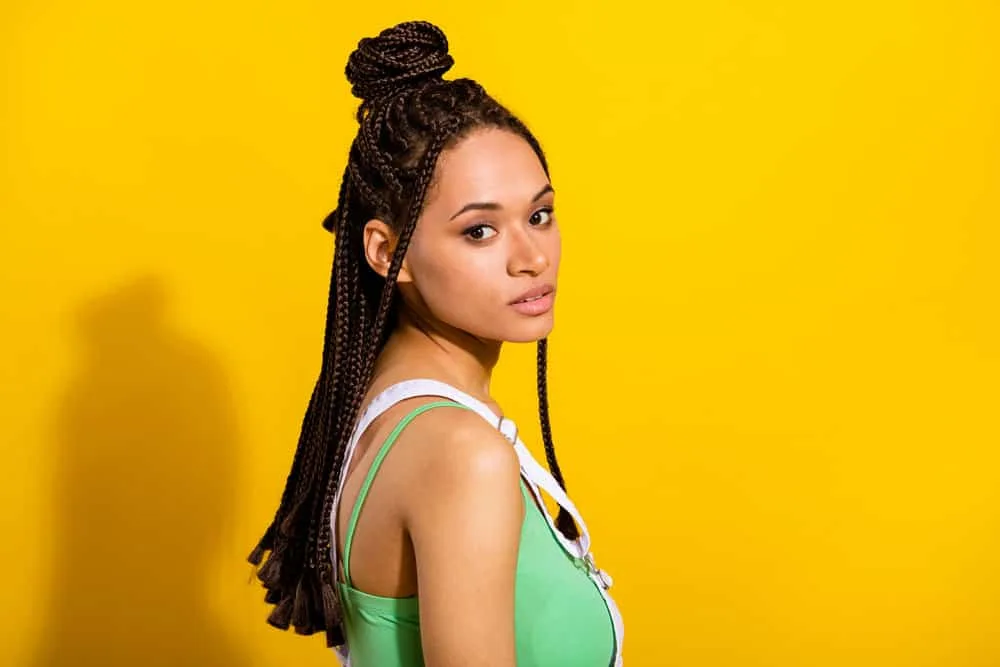 How Long Can You Keep Braids in Your Hair Without Issues? 1 A cute black female wearing a braided protective style with synthetic hair that looks like traditional box braids.