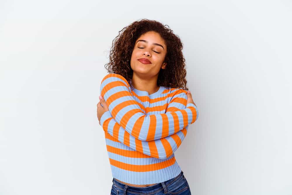 A cute young black girl with reddish curls after using hair bleaching products and layering on permanent dyes.