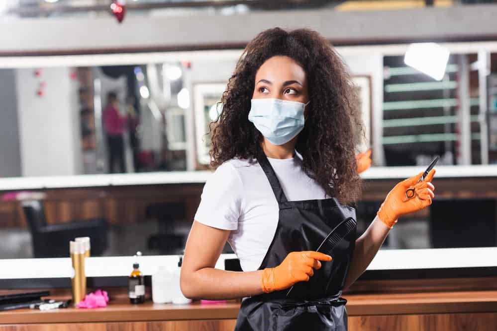 A light-skinned black lady with healthy hair gives women's haircuts and men's haircuts by appointment at a local salon.