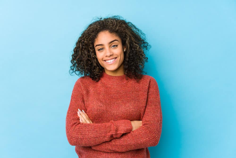 A young African American female with fine hair used too much conditioner on trying to keep her hair healthy.