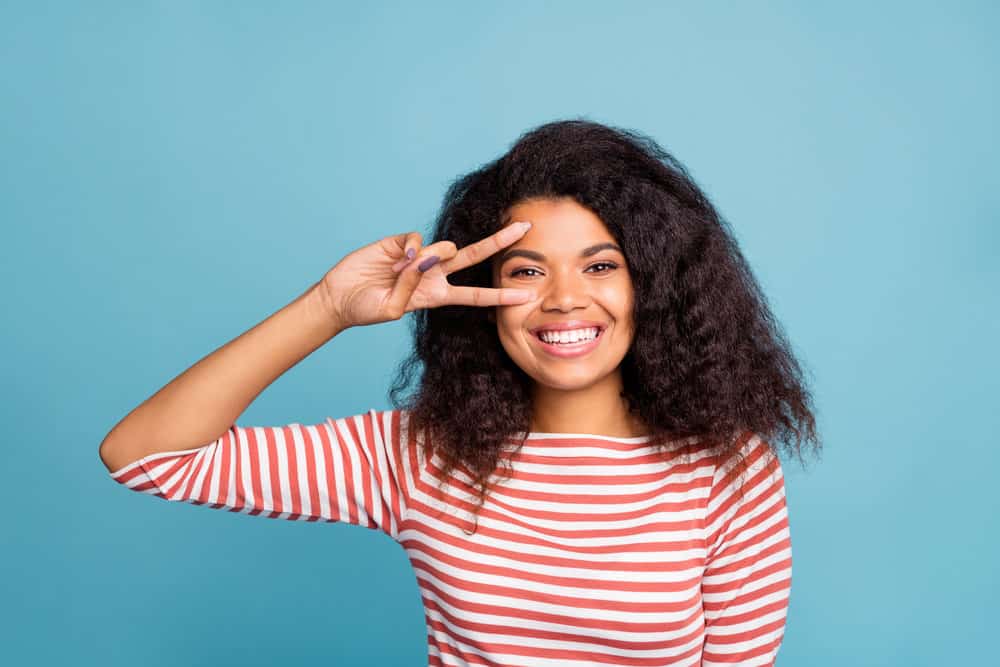 An African American female with coarse hair has thinning ends and hair shaft damage planning to get a trim.