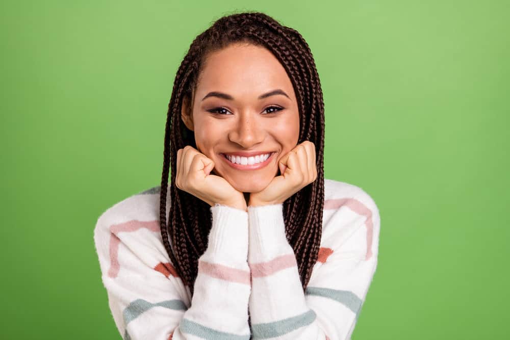 A cheerful young female with synthetic hair extensions combined with her real hair moisturized with coconut oil.