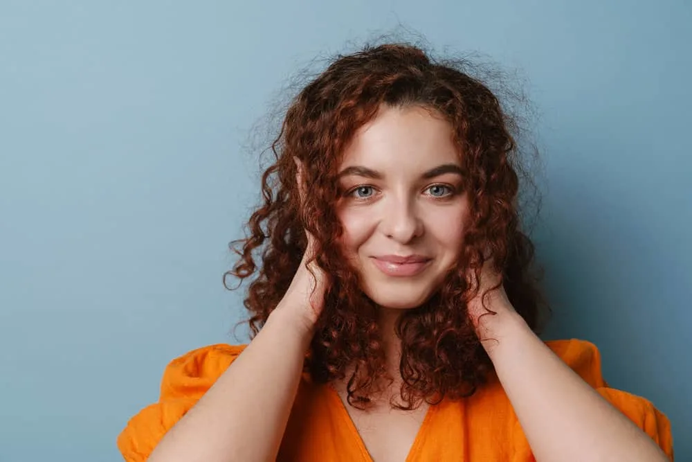 Get a Perm Out: How to Unperm Your Hair Naturally at Home 1 A naturally curly girl with healthy hair wearing her frizzy hair in a standard style created with a wide tooth comb.