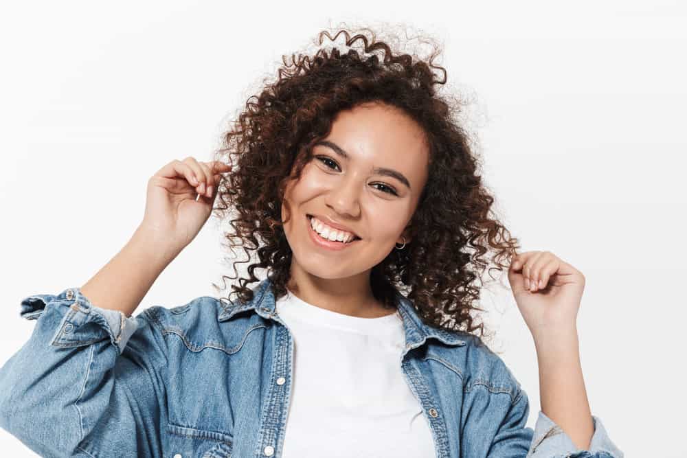 A beautiful young black female with shorter layers as her hair grows out following a layered cut to add volume.