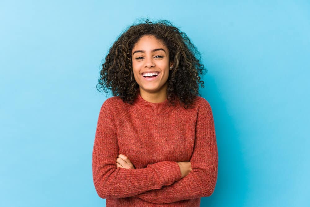 An African American female used conditioner to gently massage her hair and scalp to encourage hair growth.