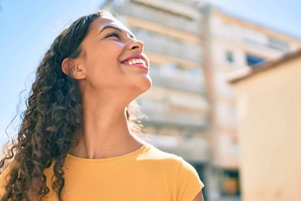 How Long Does It Take for Edges to Grow Back? Bald Edges? 8 A cute young black woman with curly hair strands sleeps in a protective style to avoid hair follicle breakage at night.