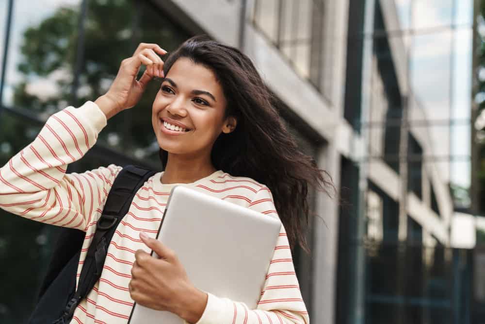 A black lady with thick hair that washed her hair with a moisturizing shampoo is wearing a dark brown straight style. 