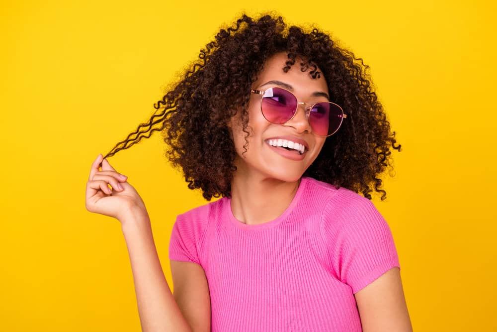 A dreamy female that allows her hair to air dry after previously experiencing damage from using blow dryers.