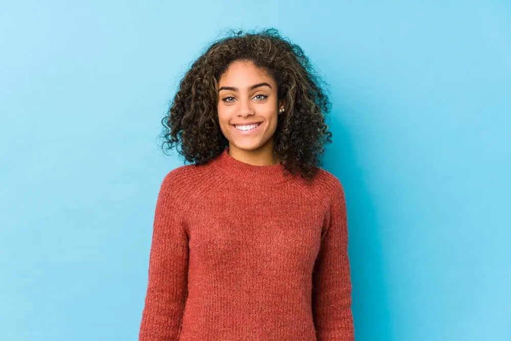 How Often Should I Use Conditioner on My Hair in a Week? 2 A young African American female with dry hair uses a cleansing conditioner routine to make her frizzy hair soft.