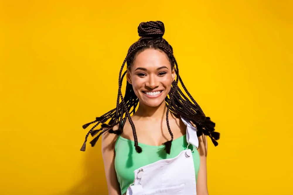 How Long Can You Keep Braids in Your Hair Without Issues? 4 An attractive African American female with thick hair wearing a protective hairstyle to encourage hair growth.