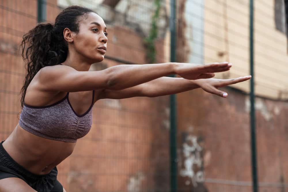 A focused young black lady wearing a sports outfit that provides a cooling sensation while she works out.