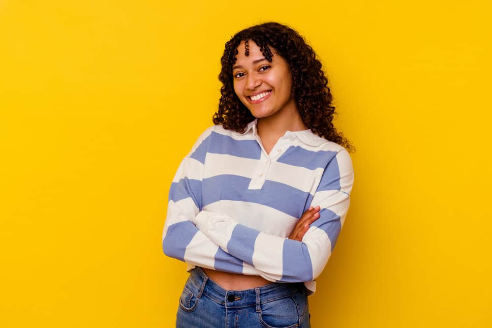 A cute young mixed-race female with new growth after incorporating scalp massages into her hair growth regimen.