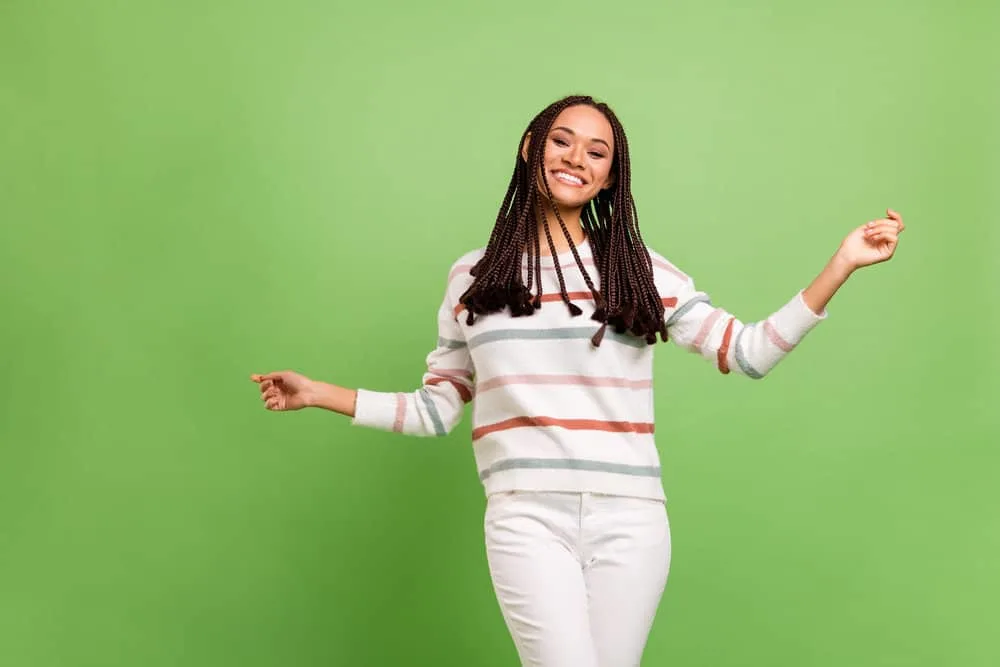 How To Soften Synthetic Braids: Step-by-Step for Beginners 8 A nice dark skin female wearing braids where the hair extension tips are loose like tiny wavy craft tassels.
