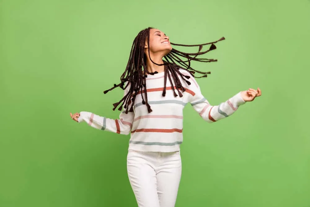 How To Soften Synthetic Braids: Step-by-Step for Beginners 7 A young female wearing a braided synthetic wig is enjoying music while dancing.