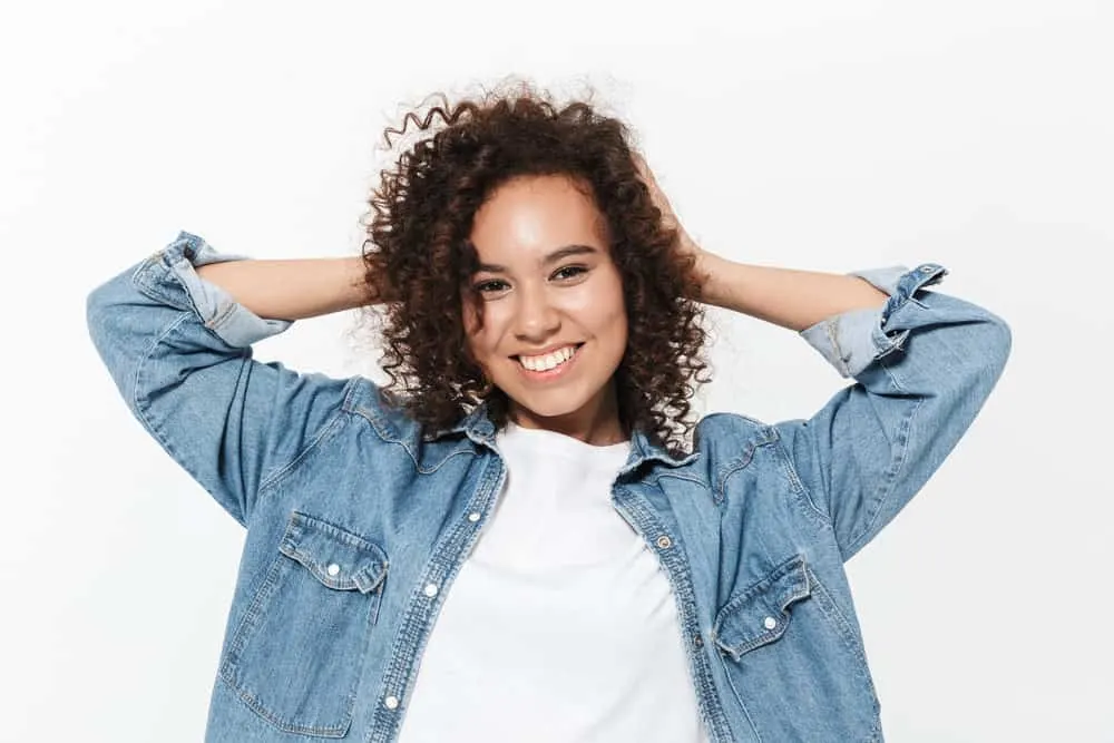 How to Get Rid of Layers in Hair: DIY Step-by-Step Guide 5 African American female with freshly trimmed layered hair styled with a smoothing serum to create more thickness.
