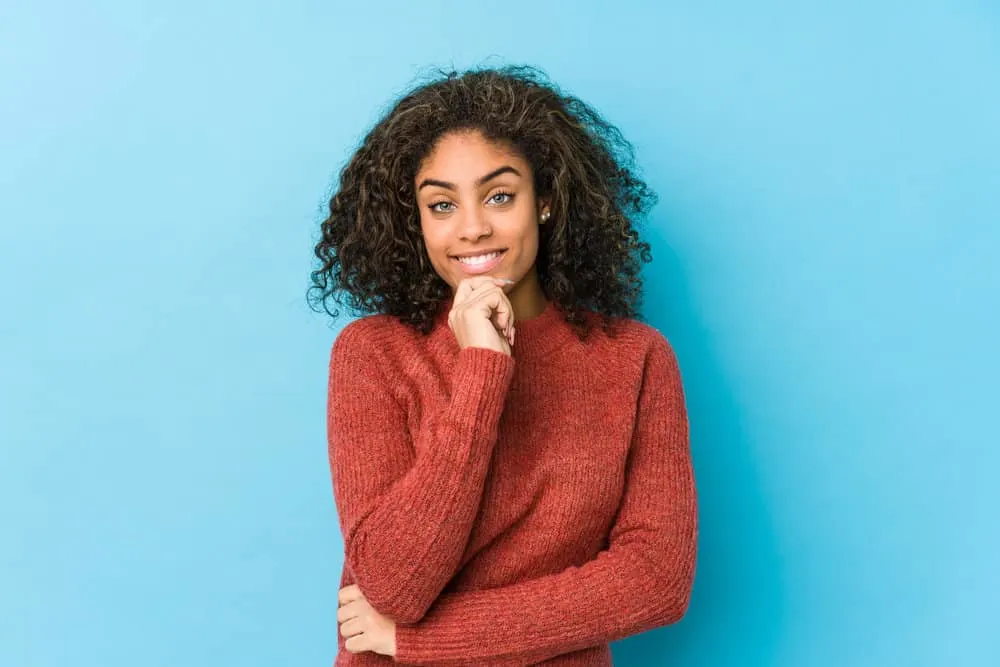 How Often Should I Use Conditioner on My Hair in a Week? 4 A young black female with shiny coarse hair has split ends and used conditioner to repair the hair's cuticle.