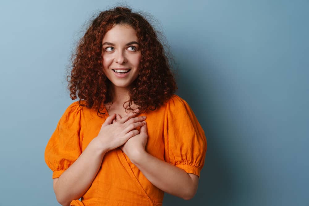 A white girl with a perm chemical treatment has a naturally straight hair shaft that has been transformed to super curly.