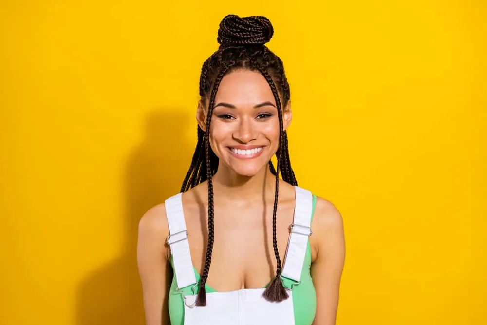 How Long Can You Keep Braids in Your Hair Without Issues? 6 An adorable young black woman wearing braids keeps her hair hydrated with leave-in conditioners and Nexxus style.