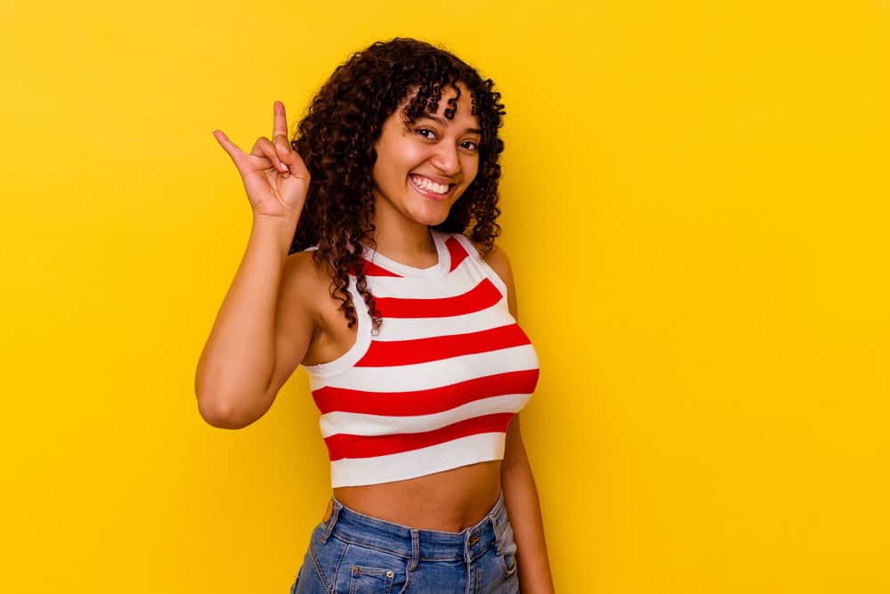 A cute female with a tighter curl pattern styled her natural type 3 curls with a curl cream and a leave-in moisturizer.