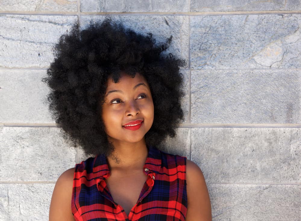 A black female with a type 4 curl texture and tight corkscrews in an afro style was created with styling cream.