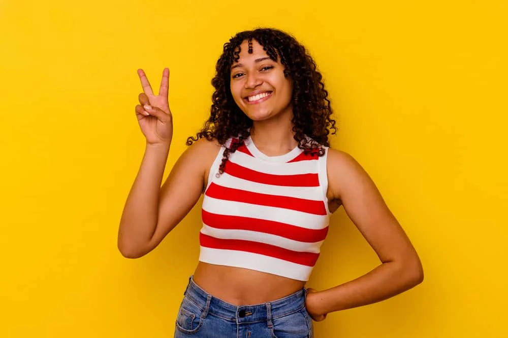 Curly vs. Kinky Hair: Difference Between Curly and Kinky Hair 2 A mixed-race female with a higher curl pattern is wearing her natural hair in a loose style that highlights her curl type.