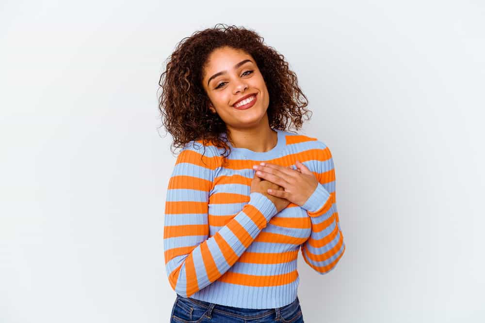 A young black girl with naturally dark hair underwent a hair-bleaching process to create a light brown hair color.