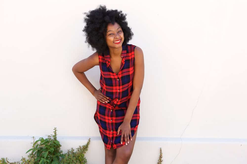 A fashionable female with a looser curl pattern with two textures - type 3 and type 4 curls - no straight hair strands.