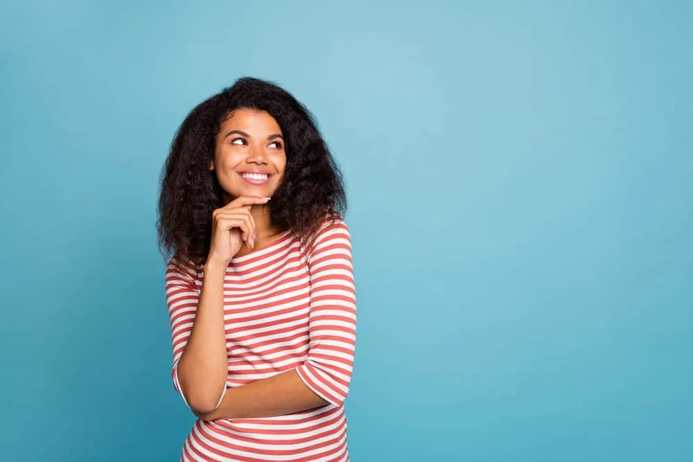 How Much Hair Is Cut Off in a Trim and Signs You Need a Trim 5 A young black lady with type 3 natural hair styled in a layered hair-cut that's starting to experience damaged ends.