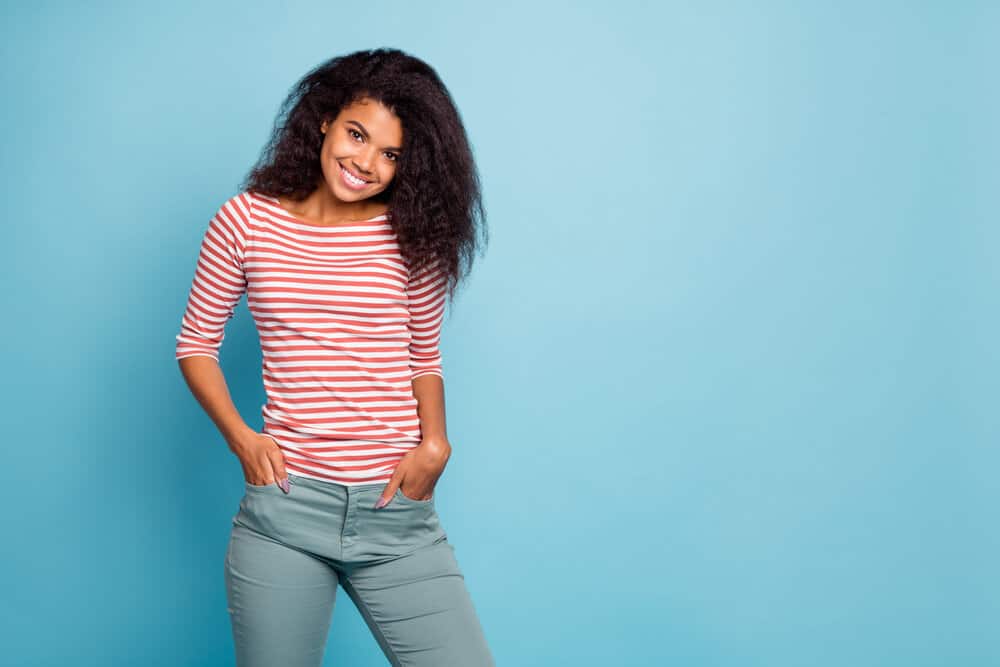 A light-skinned black female with an adorable smile has straight hair with a slightly wavy pattern.