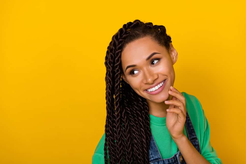 A charming girl after detangling her severely tangled hair and installing box braids using a medium tooth comb.