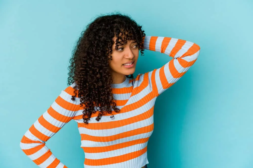 Why Does My Hair Smell Bad After I Wash It? Even Every Day? 3 A lady with curly hair follicles washed with a medicated shampoo and styled with tea tree oil and other essential oils.