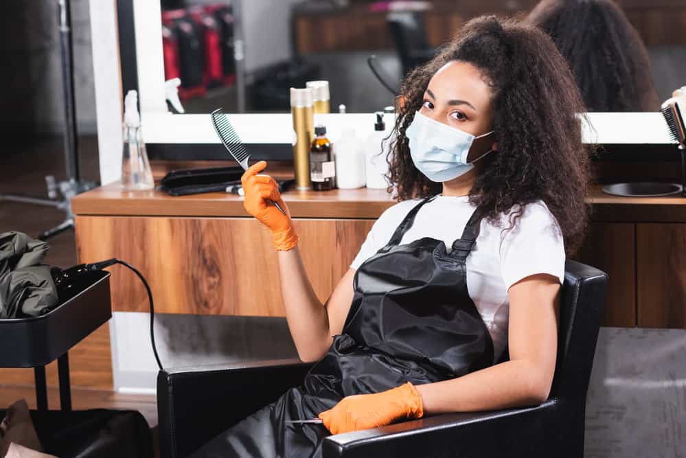 An African stylist with long hair provides shampoo and hair cut services in a higher-end West Virginia hair salon.