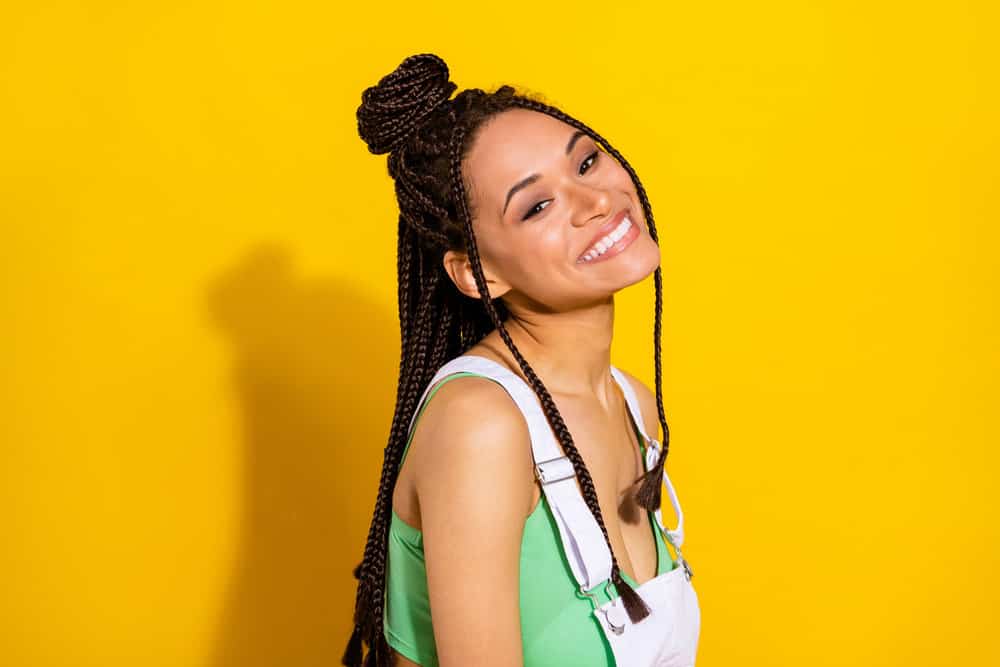 An adorable African American female with braided hair in long box braids made popular by a celebrity stylist.