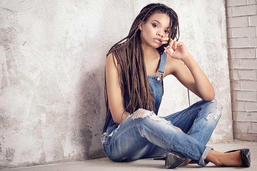 A fashionable black woman with tight braids wearing human hair extensions on her 4A textured hair strands.