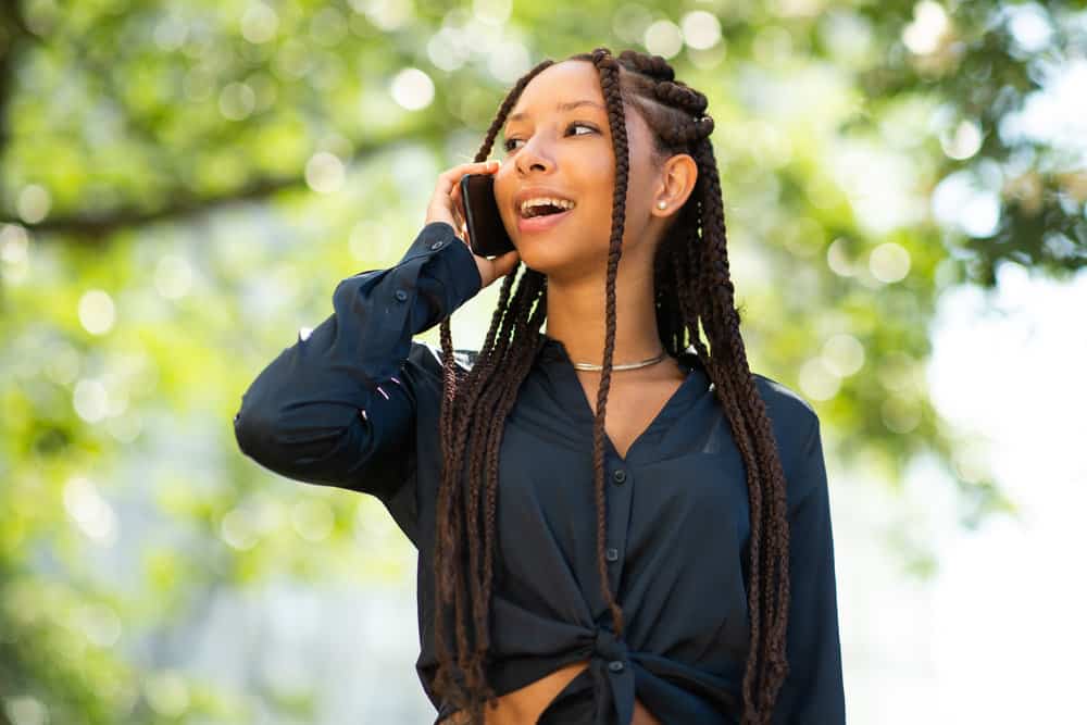 Light-skinned black girl wearing faux locs that keeps her hair hydrated with a coconut oil and water mix.