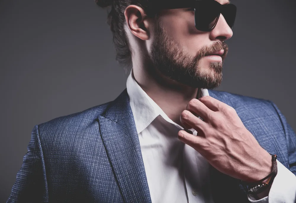How to Do a Man Bun: Step by Step with Short or Long Hair 3 A young white guy with thick hair wearing a twisted man bun (or bro bun) with loose ends styled with hair oil.
