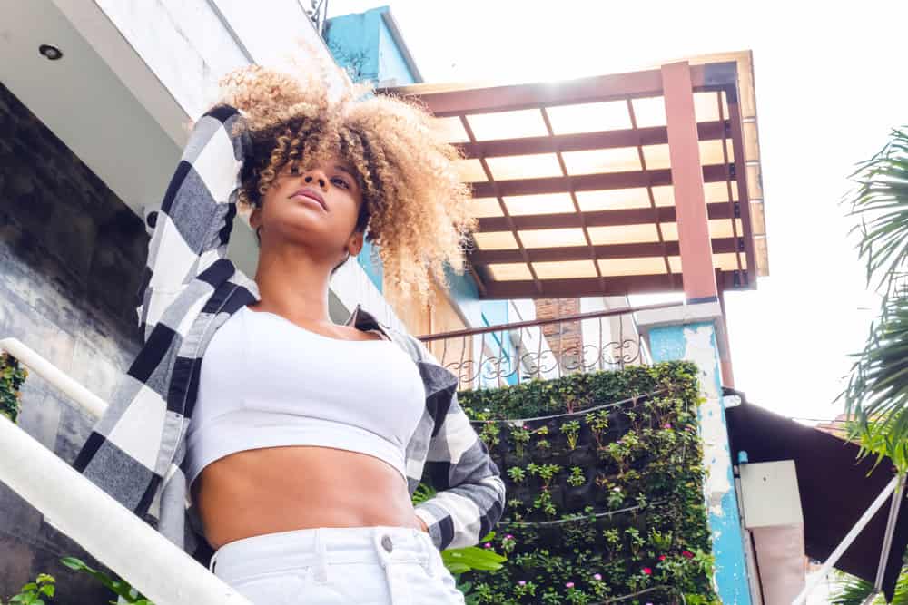 A beautiful black female with long hair and curly bangs on her type 3a and 3b hair types showing off new hair growth.